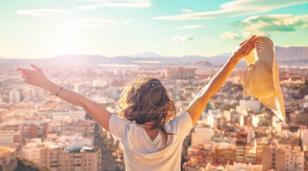 Foto de Feliz joven con los brazos levantados disfrutando de la vista panorámica del horizonte de Málaga - Imagen libre de derechos