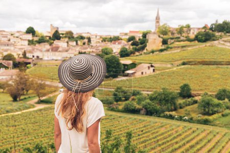 Rückansicht einer Frau mit Blick auf einen grünen Weinberg in der Region Bordeaux, Saint Emilion - Frankreich, Nouvelle Aquitaine
