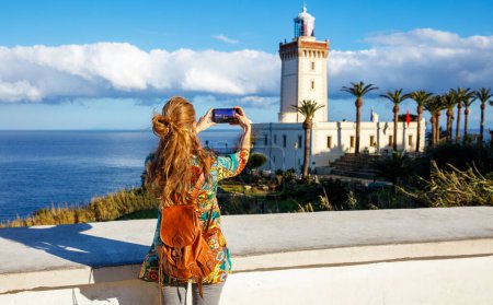 Photo for Tourism in Morocco-woman tourist taking photography of cap spartel, tanger - Royalty Free Image
