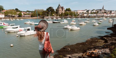Foto de Castillo y puerto córnico, vista trasera de la mujer viajera disfrutando de vista panorámica- Loira Atlantique, Pays de la loire - Imagen libre de derechos