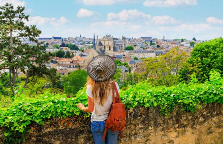 Photo for Panoramic view of Poitiers- Woman with hat and bag looking at city view- France - Royalty Free Image