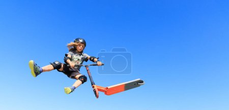 Foto de Joven saltando con scooter freestyle en skatepark urbano- trucos de salto en scooter- freestyle, deporte, concepto extremo - Imagen libre de derechos