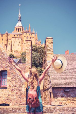 Foto de Mujer viajando por Francia visitando la famosa ciudad de Mont Saint Michel Normandía - Imagen libre de derechos