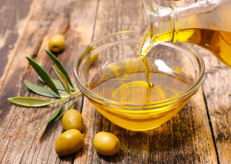 Photo for Olive oil and leaf on wood background - Royalty Free Image
