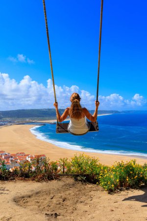 Foto de Persona en un columpio disfrutando de hermosa playa y el océano atlántico- Portugal - Imagen libre de derechos