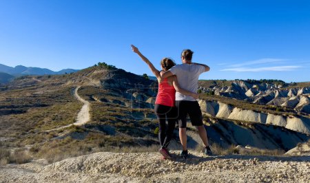 Téléchargez les photos : Couple randonneur bénéficiant d'une vue panoramique sur la montagne- mode de vie sain, aventure, concept sportif - en image libre de droit