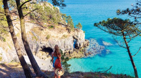 Téléchargez les photos : Femme avec chapeau regardant la plage tropicale paradisiaque- Voyage d'été, concept de vacances- Bretagne en France - en image libre de droit