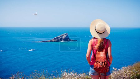 Téléchargez les photos : Vue arrière du voyageur femme qui regarde la mer- destination de voyage, la luxure de l'errance, concept de vacances- (Bretagne en France) - en image libre de droit