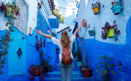 Téléchargez les photos : Happy woman touriste dans la rue bleue Chefchaouen- Voyage au Maroc - en image libre de droit