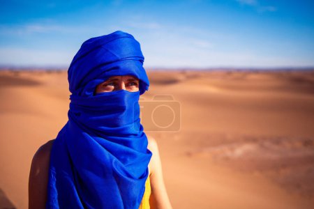 Foto de Retrato de mujer con turbante azul mirando al desierto - Imagen libre de derechos