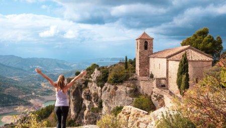 Téléchargez les photos : Femme randonneuse à bras ouverts sur une falaise bénéficiant d'une vue magnifique sur le paysage- Siurana en Espagne - en image libre de droit