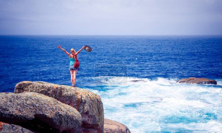 Foto de Mujer de pie en el acantilado disfrutando del mar - Imagen libre de derechos