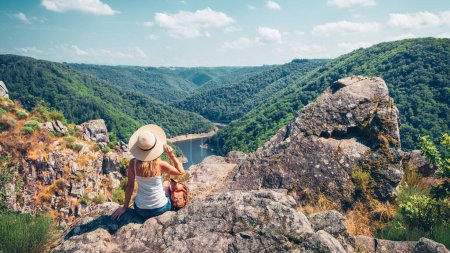 Foto de Mujer sentada en el pico disfrutando de hermosas vistas- viajes, aventura, vagabundeo concepto (Dordoña en Francia) - Imagen libre de derechos