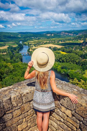 Téléchargez les photos : Femme touriste bénéficiant d'une belle vue sur la rivière Dordogne et le paysage- Tourisme en France - en image libre de droit