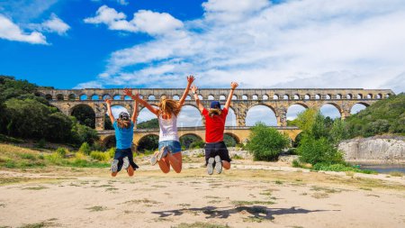 Téléchargez les photos : Bonne famille voyageant en France- Pont du Gard- tourisme d'excursion, Voyage, vacances dans le Gard - en image libre de droit