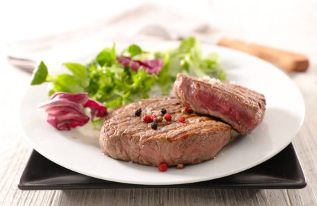 Téléchargez les photos : Steaks de bœuf grillés avec salade - en image libre de droit