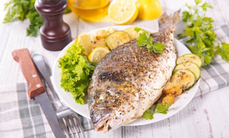 Photo for Roasted fish with potatoes and salad - Royalty Free Image