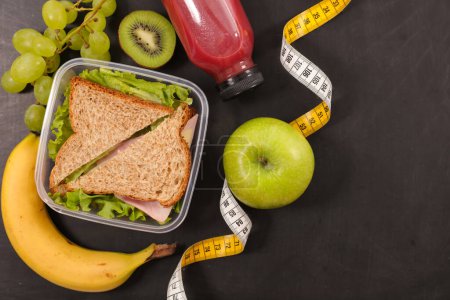 Téléchargez les photos : Boîte à lunch saine avec sandwich et fruits frais- aliments diététiques, concept de saine alimentation - en image libre de droit