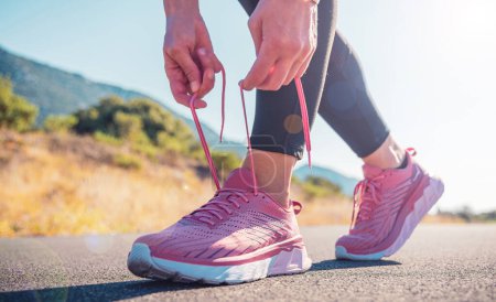 Téléchargez les photos : Femme attachant lacets de chaussures de course coureur Jogging, exercice motivation santé et fitness concept - en image libre de droit