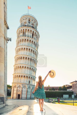 Foto de Mujer con sombrero y vestido azul disfrutando de la Torre Inclinada en Pisa en Italia- turismo turístico, viajes, vacaciones en Europa - Imagen libre de derechos