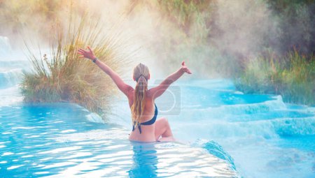 Photo for Young female tourist enjoying Natural spa with waterfalls at Saturnia thermal baths- Tuscany in Italy- Hot spring, wellness, health care - Royalty Free Image