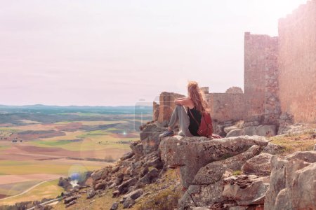 Téléchargez les photos : Femme assise sur le rocher profitant d'une vue panoramique sur le paysage espagnol- Province de castille de Léon en Espagne - en image libre de droit