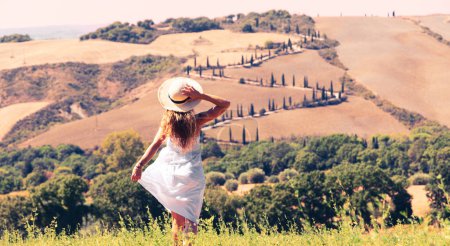 Foto de Atractiva joven hembra con sombrero y vestido blanco viajando en Toscana Italia - Imagen libre de derechos
