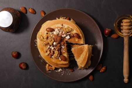 Photo for Homemade american pancakes with dried nuts and syrup - Royalty Free Image
