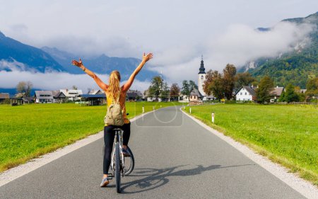 Photo for Happy woman on bike enjoying road to mountain in Slovenia- Sport, travel,active lifestyle concept - Royalty Free Image