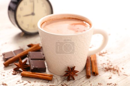Photo for Hot chocolate with spices and alarm clock in the background- morning, wake up concept - Royalty Free Image