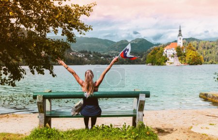 Photo for Travel destination in Slovenia- tour tourism on Bled lake, Woman tourist holding Sloven flag - Royalty Free Image