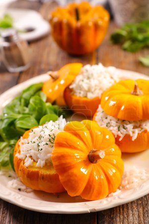 Foto de Calabazas pequeñas rellenas de arroz plato vegetariano-Halloween, comida de otoño - Imagen libre de derechos