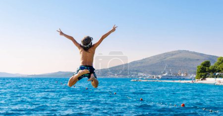 Téléchargez les photos : Enfant sautant dans la mer en Croatie - en image libre de droit