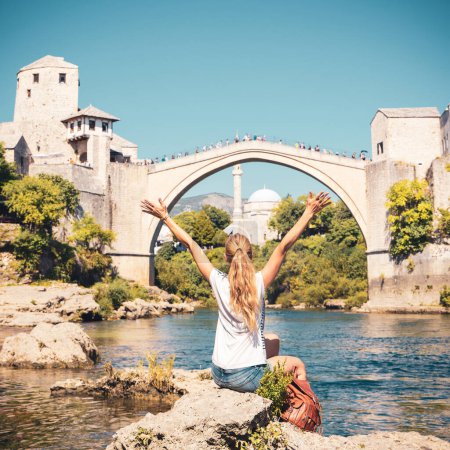 Téléchargez les photos : Voyageuse heureuse dans la ville de Mostar Vieux pont et rivière tourisme d'excursion, voyage, destination de vacances - en image libre de droit