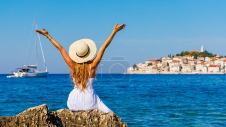 Téléchargez les photos : Femme en robe blanche bénéficiant d'une vue panoramique sur la ville et la vue sur le yacht Voyage, vacances, tourisme touristique en Croatie-Europe - en image libre de droit