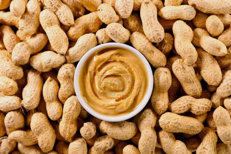 Photo for Peanut butter in bowl with peanut background - Royalty Free Image