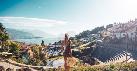 Photo for Woman tourist looking at panoramic view of ancient roman theater in Ohrid in Macedonia - Royalty Free Image