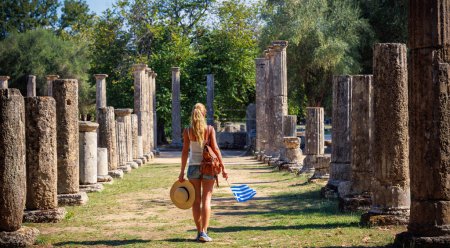Photo for Tour tourism in Greece- Peloponnese,  Ruins in ancient Olympia, Woman tourist visiting archaeologic site - Royalty Free Image