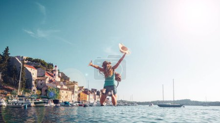 Téléchargez les photos : Happy Traveler femme sautant avec les bras levés en Europe - en image libre de droit