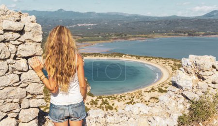 Téléchargez les photos : Femme touriste profitant de la vue sur l'une des belles plages de Grèce, plage Voidokilia, Pylos, Péloponnèse en Grèce- Voyage, tourisme d'excursion, vacances - en image libre de droit