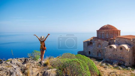 Foto de Viajero mujer caucásica en Grecia- iglesia ortodoxa típica y el mar mediterráneo - Imagen libre de derechos