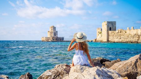 Téléchargez les photos : Joyeux voyageur femme en Grèce- La tour Bourtzi à Methoni Forteresse vénitienne dans le Péloponnèse - en image libre de droit
