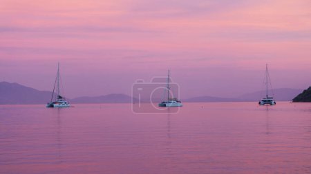 Téléchargez les photos : Beau coucher de soleil sur la mer avec trois bateaux, yacht - en image libre de droit