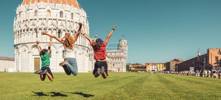 Téléchargez les photos : Heureuse famille sautant devant la cathédrale et la tour penchée à Pisa- Voyage, tourisme d'excursion, vacances en Italie - en image libre de droit