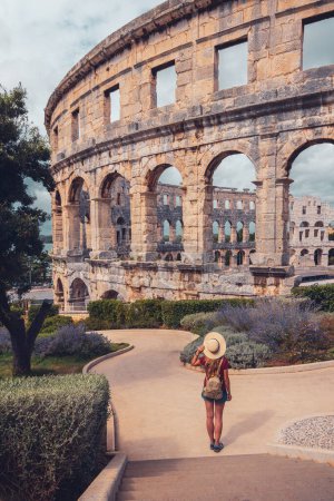 Foto de Antiguo anfiteatro romano en Pula, mujer turista que visita la ciudad en Croacia - Imagen libre de derechos