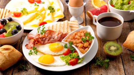Foto de Saludable desayuno completo con huevo frito, tostadas y tocino con taza de café y fruta frita - Imagen libre de derechos