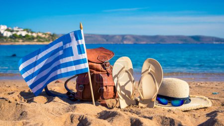 Téléchargez les photos : Destination de voyage, vacances, concept touristique drapeau grec, sac, flip-flop et lunettes de soleil sur la plage - en image libre de droit