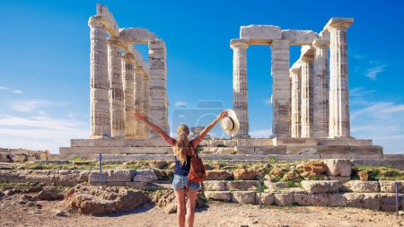 Téléchargez les photos : Femme voyageuse en appréciant les ruines antiques, Temple de Poséidon, Sounion en Grèce - en image libre de droit