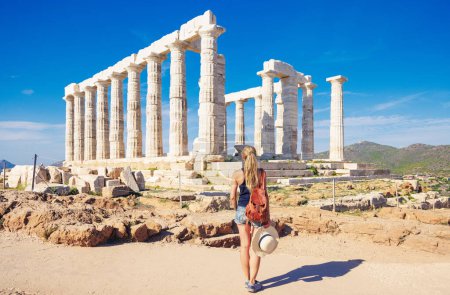 Foto de Mujer viajera en disfrutar de ruinas antiguas, Templo de Poseidón, Sounion en Grecia - Imagen libre de derechos