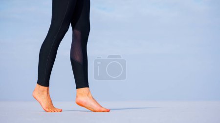 Téléchargez les photos : Jambe de femme, ceinture pieds nus marchant sur le lac de plage salée- Bien-être, mode de vie sain, concept de sérénité - en image libre de droit